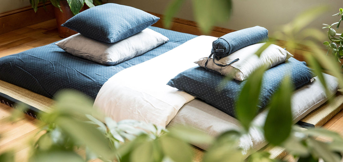 Shikibuton on a tatami mat with pillows. Surrounded by plants.