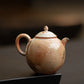 Ceramic teapot on a dark surface with a blurred background