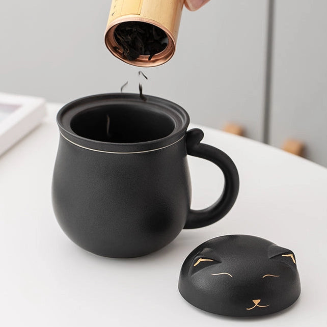 Person pouring tea into a black mug with a bamboo tea infuser, on a light gray background.