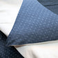 Close-up of blue fabric with a subtle pattern on a white background