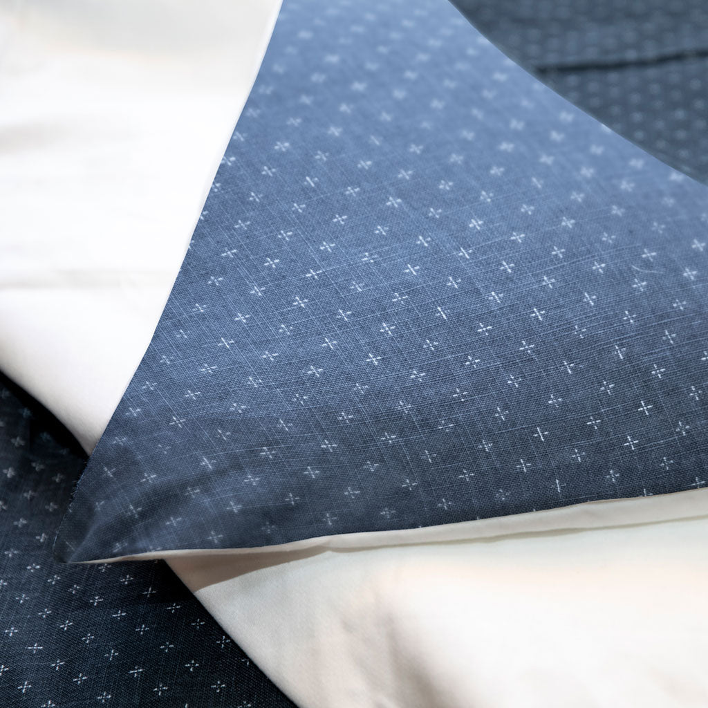Close-up of blue fabric with a subtle pattern on a white background