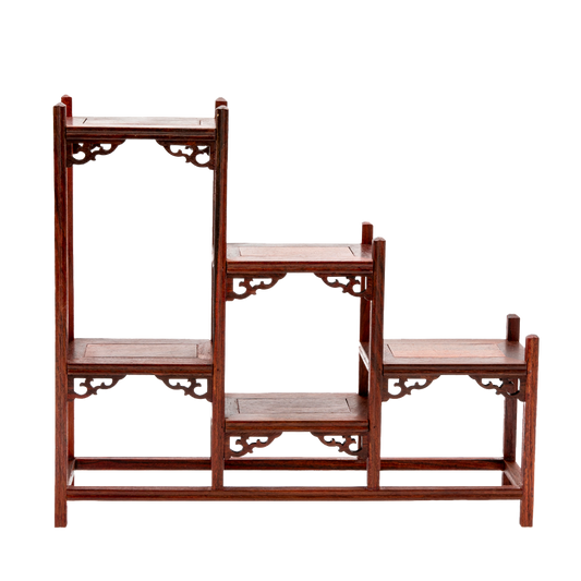 A traditional Japanese ornate rosewood shelf with scroll detailing and a stagnated 'step' design.