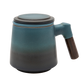 A blue ceramic tea infuser cup with a removable lid and a wooden handle.