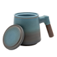 A blue ceramic tea infuser cup with a removable lid and a wooden handle.