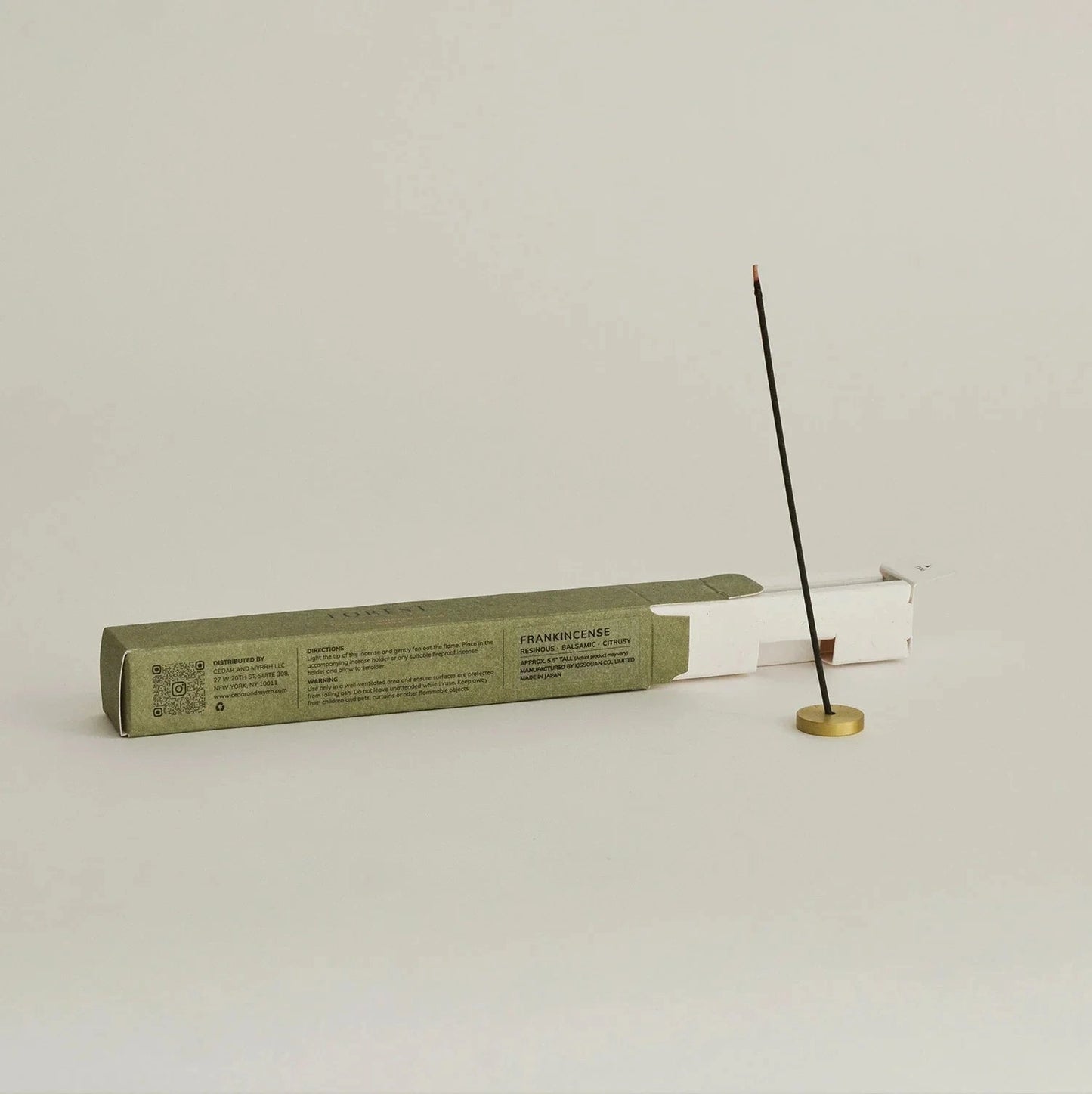 Incense stick and packaging on a light gray background