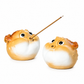 Two puffer fish-shaped ceramic incense holders on a white background, one holding a wooden incense stick.