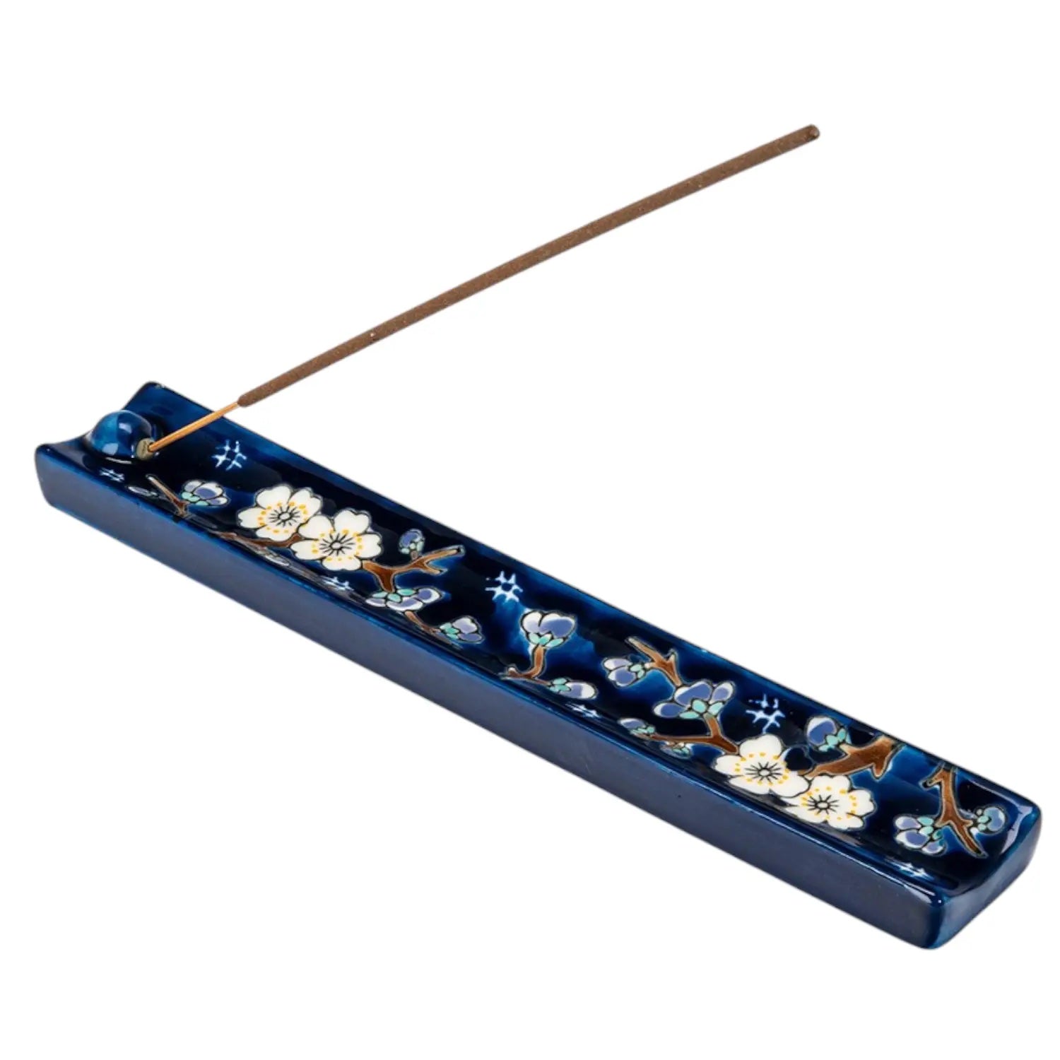 Blue incense holder with floral design and incense stick on a white background
