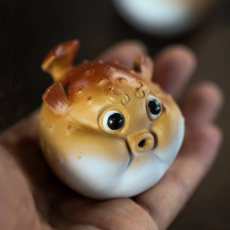 Pufferfish incense holder resting on a hand.