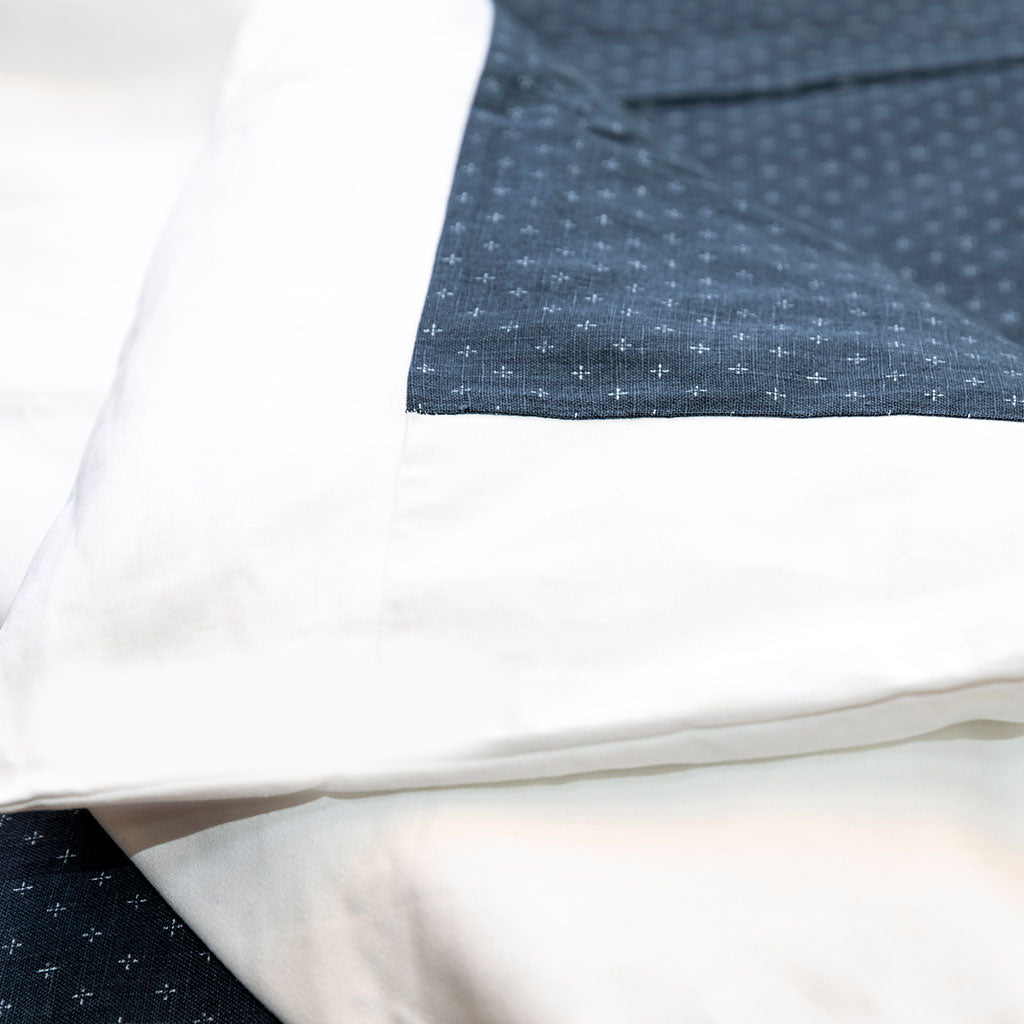 Close-up of white and blue fabric with a subtle pattern on a light background