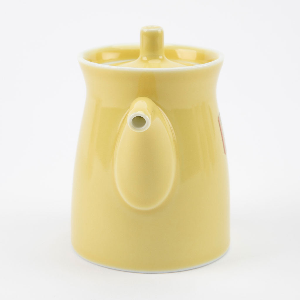 Yellow ceramic soy sauce dispenser on a white background
