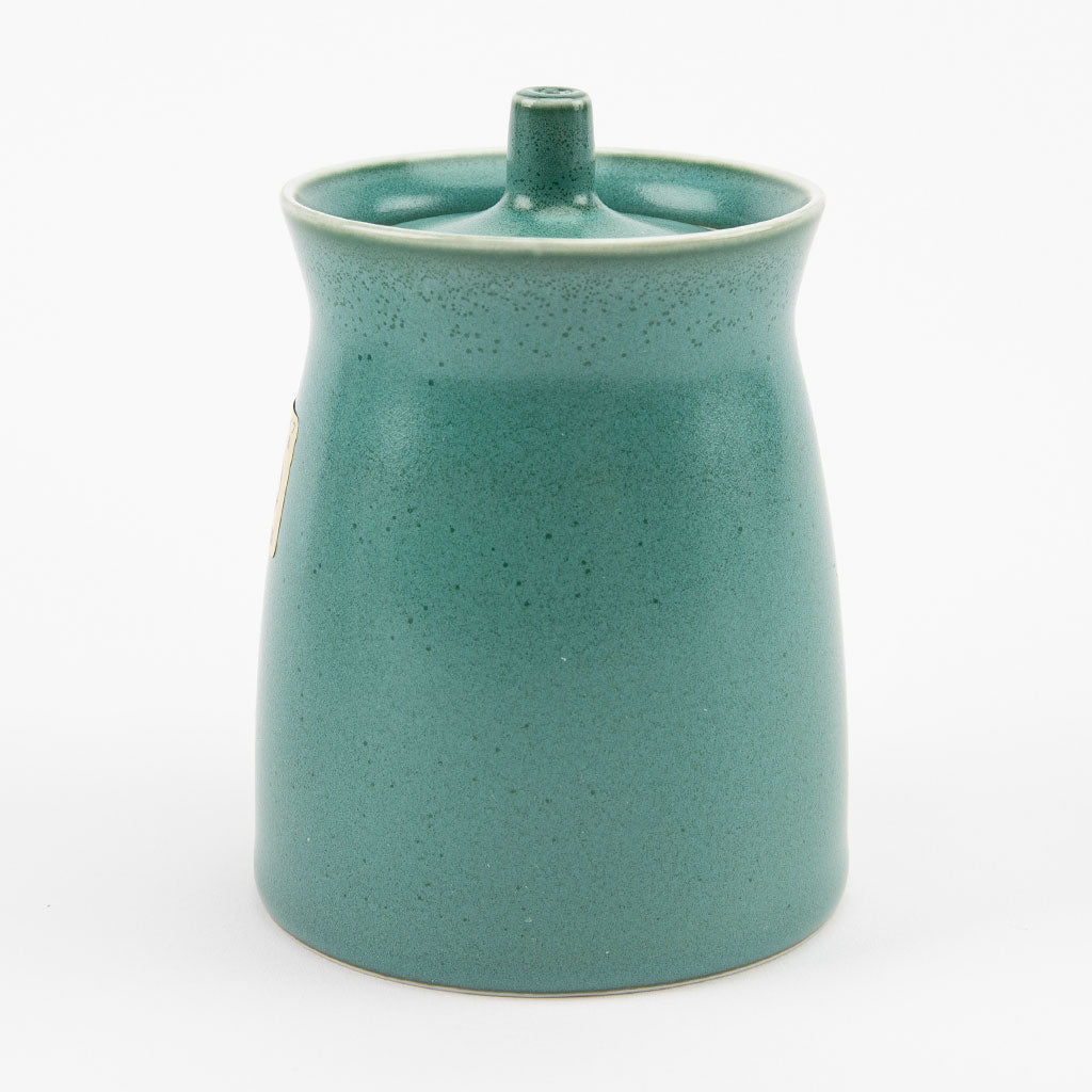 Green ceramic soy sauce dispenser on a white background