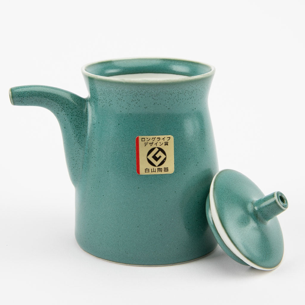 Teal ceramic soy sauce dispenser with a lid on a white background