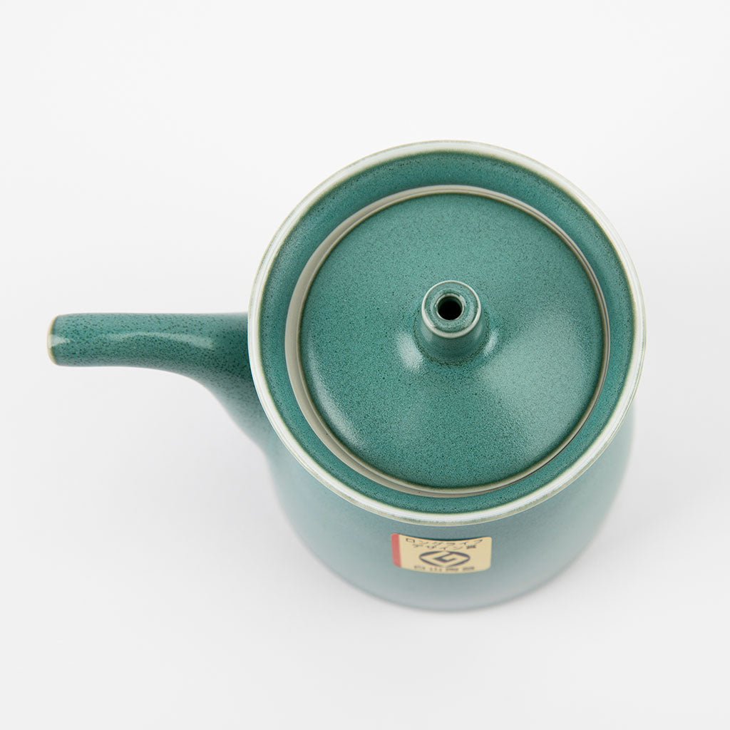 Teal ceramic soy sauce dispenser with lid on a white background