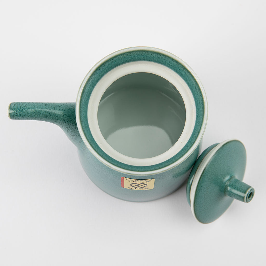 Green ceramic soy sauce dispenser with a lid on a white background