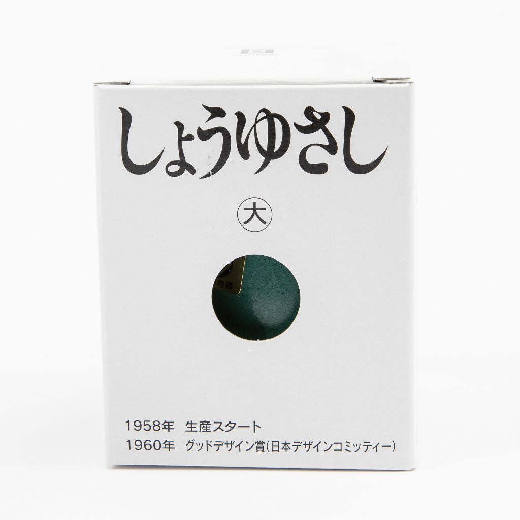 White packaging with black text and a green round object on a white background