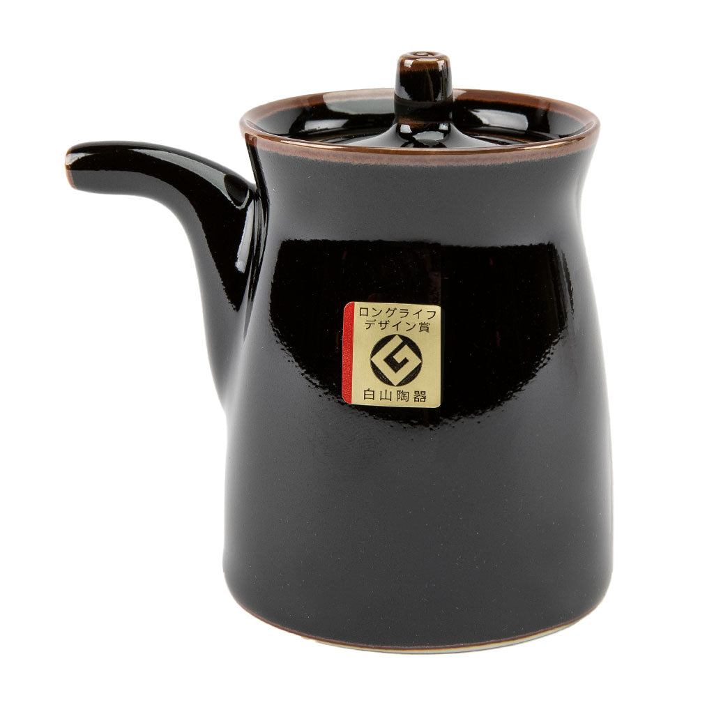 Black ceramic soy sauce dispenser with a brand label on a white background