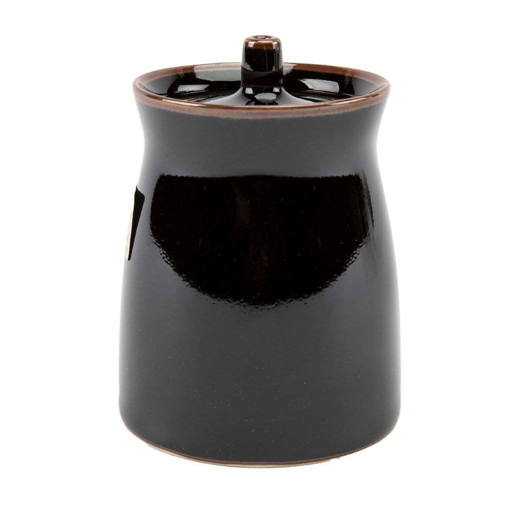 Black ceramic soy sauce dispenser with a lid on a white background