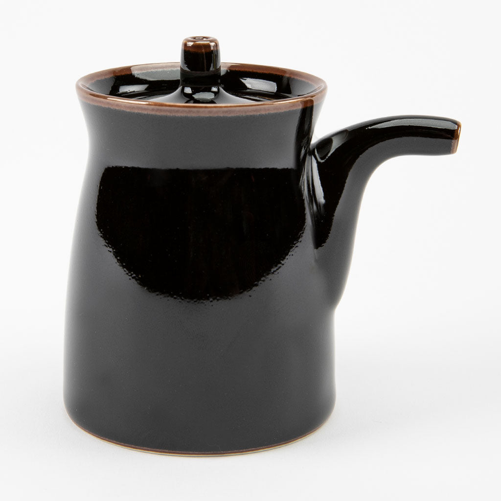Black ceramic soy sauce dispenser on a white background