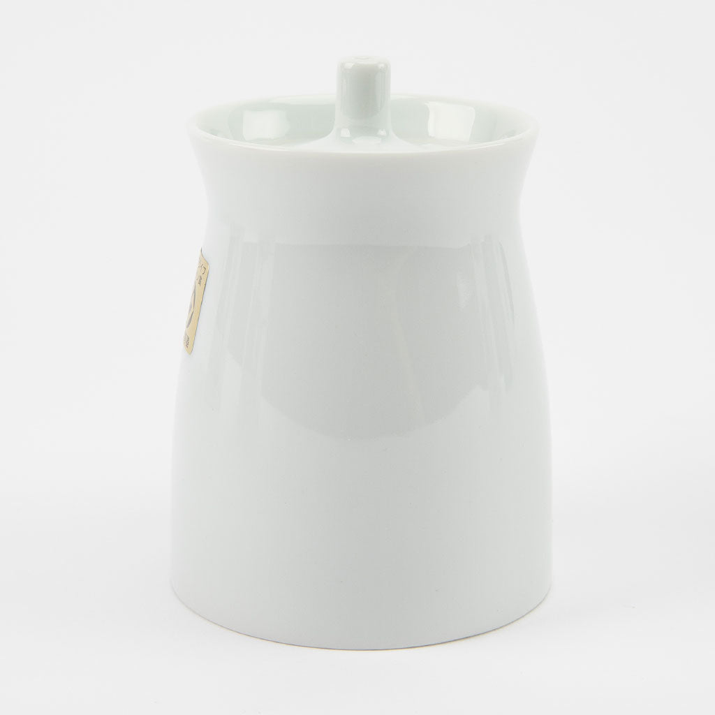 White ceramic soy sauce dispenser with a small handle on a light gray background