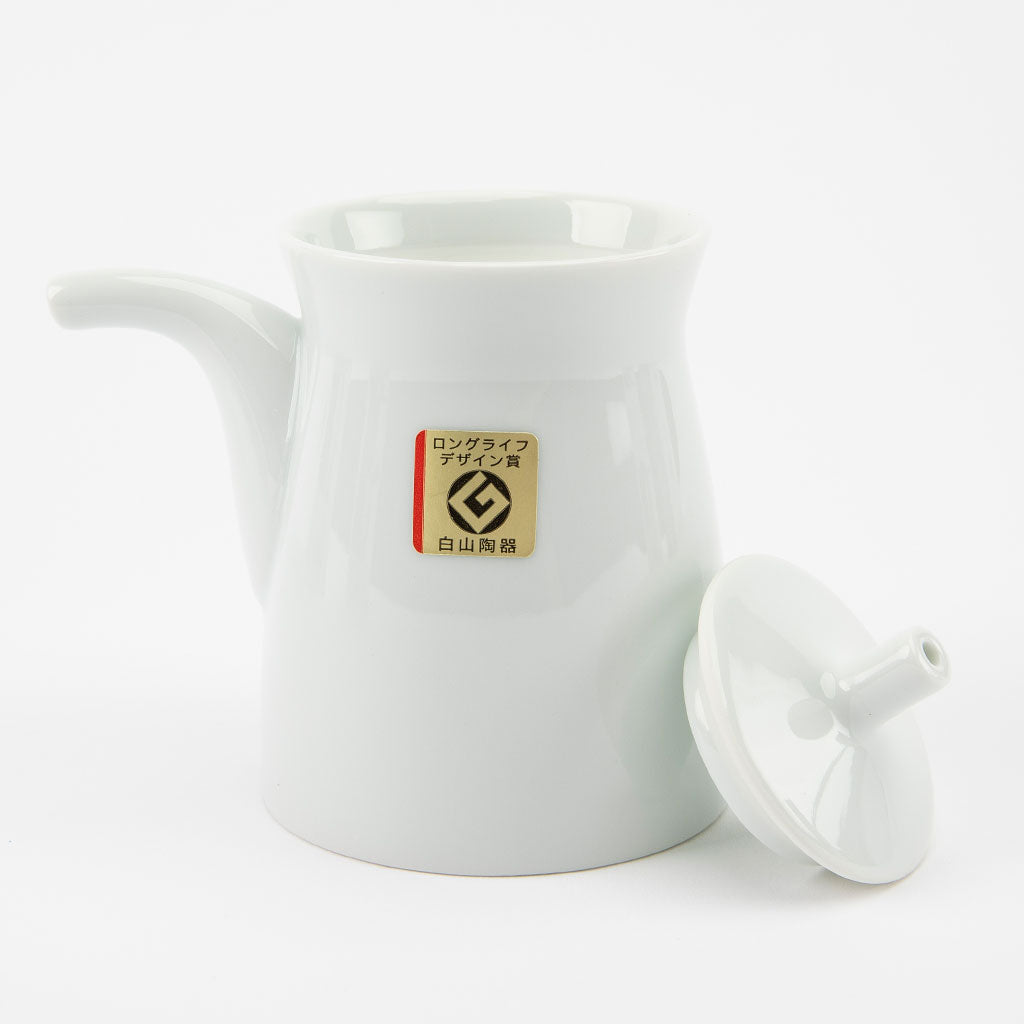White ceramic soy sauce dispenser with a lid on a white background