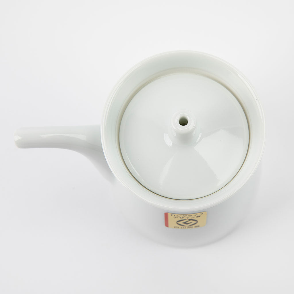 White ceramic soy sauce dispenser with lid on a white background