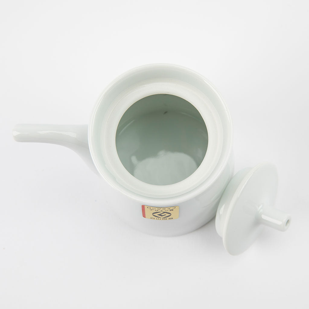 White ceramic soy sauce dispenser with a lid on a white background