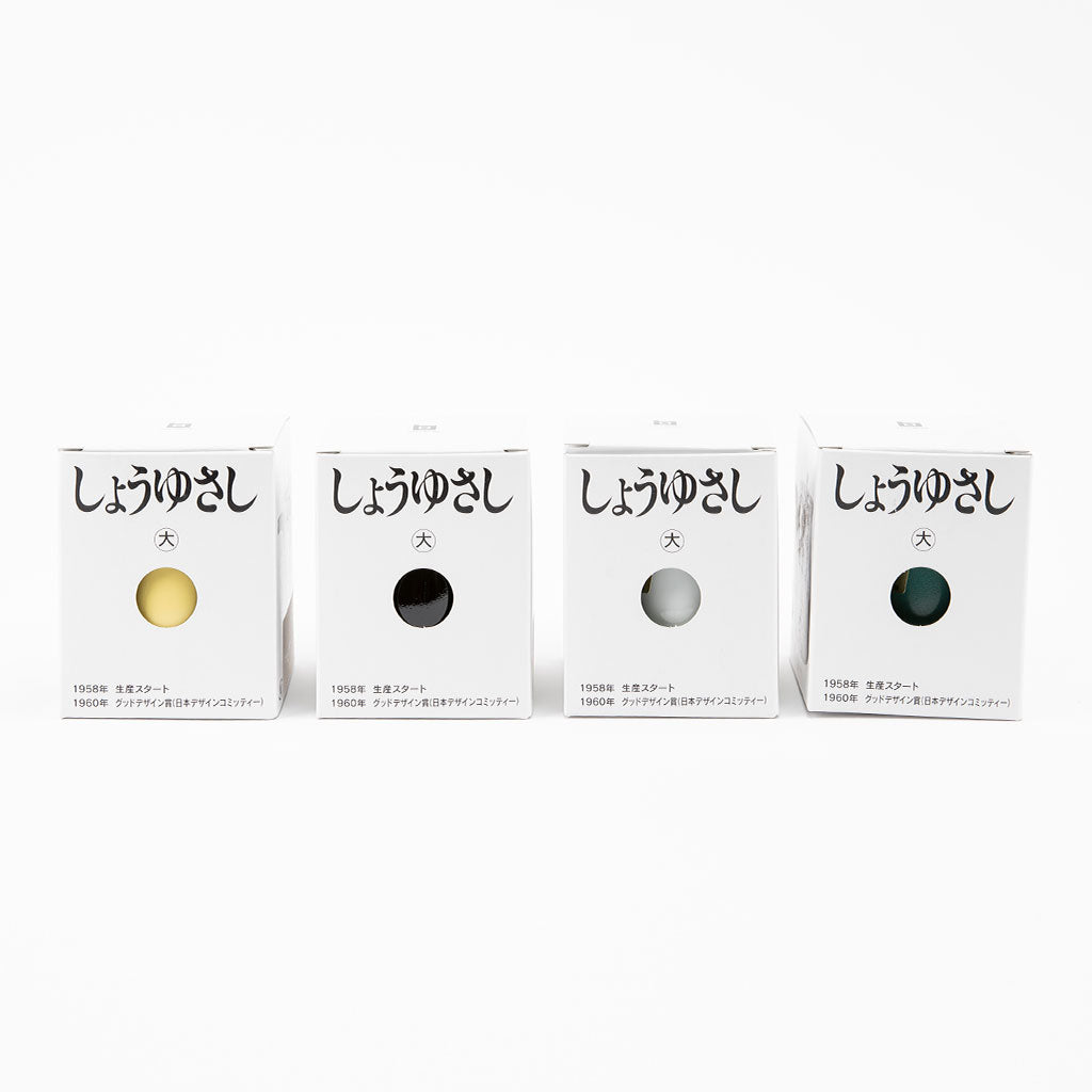 Four soy sauce dispensers in a white case on a white background