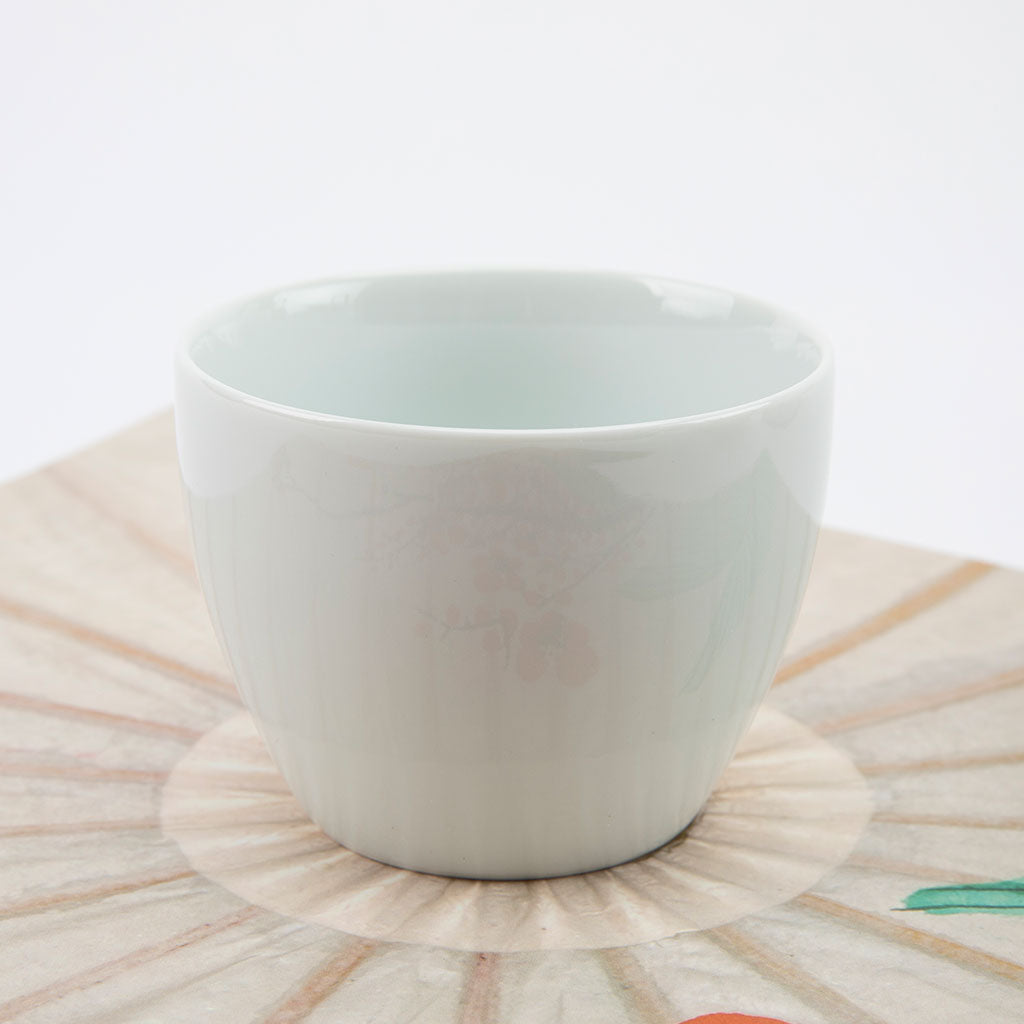 White ceramic bowl on a decorative plate with a white background