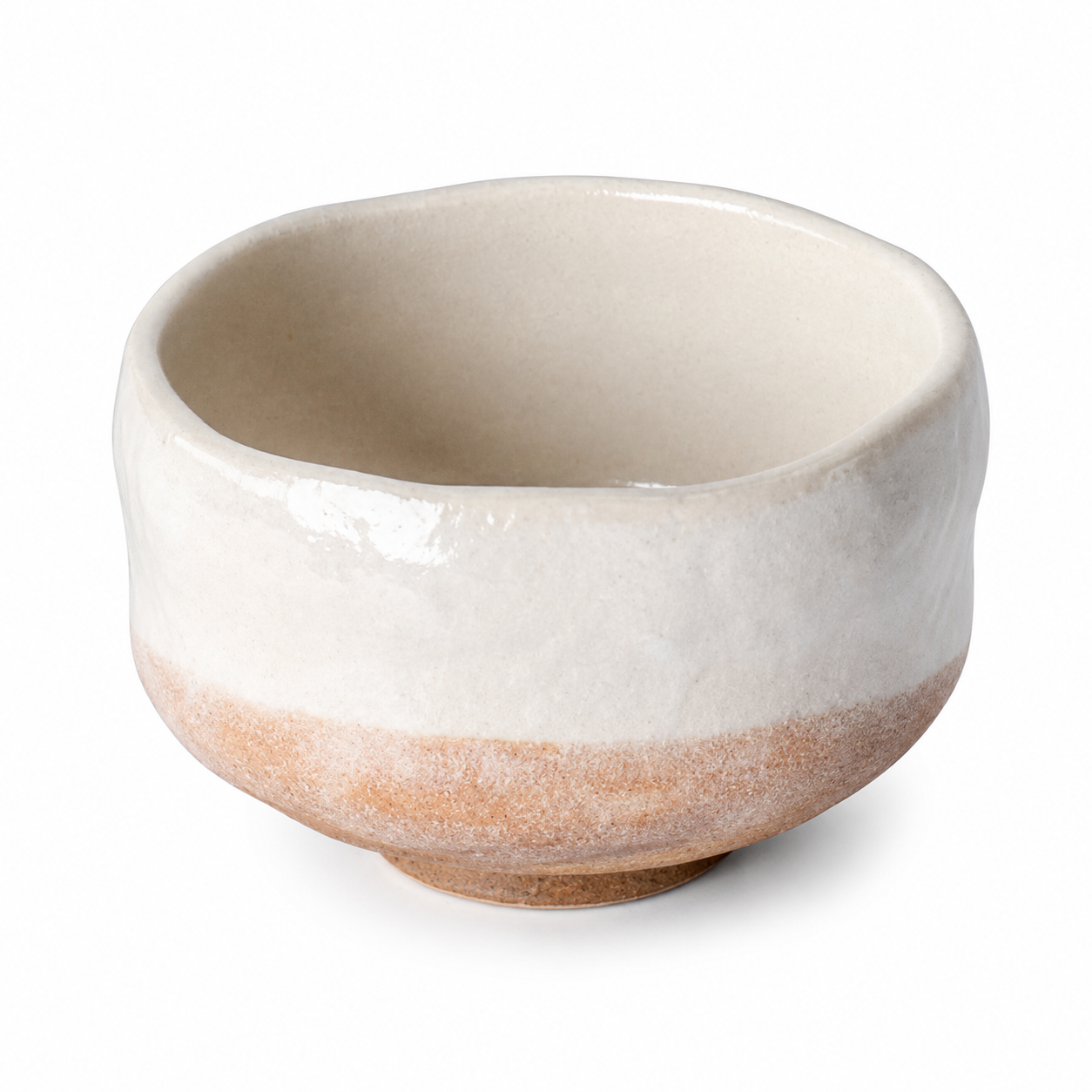 A handmade ceramic tea bowl with a glossy off-white glazed finish on the upper half and a textured, matte light brown unglazed band on the lower half, set against a plain white background.