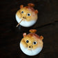Two puffer fish incense holders on a dark table.