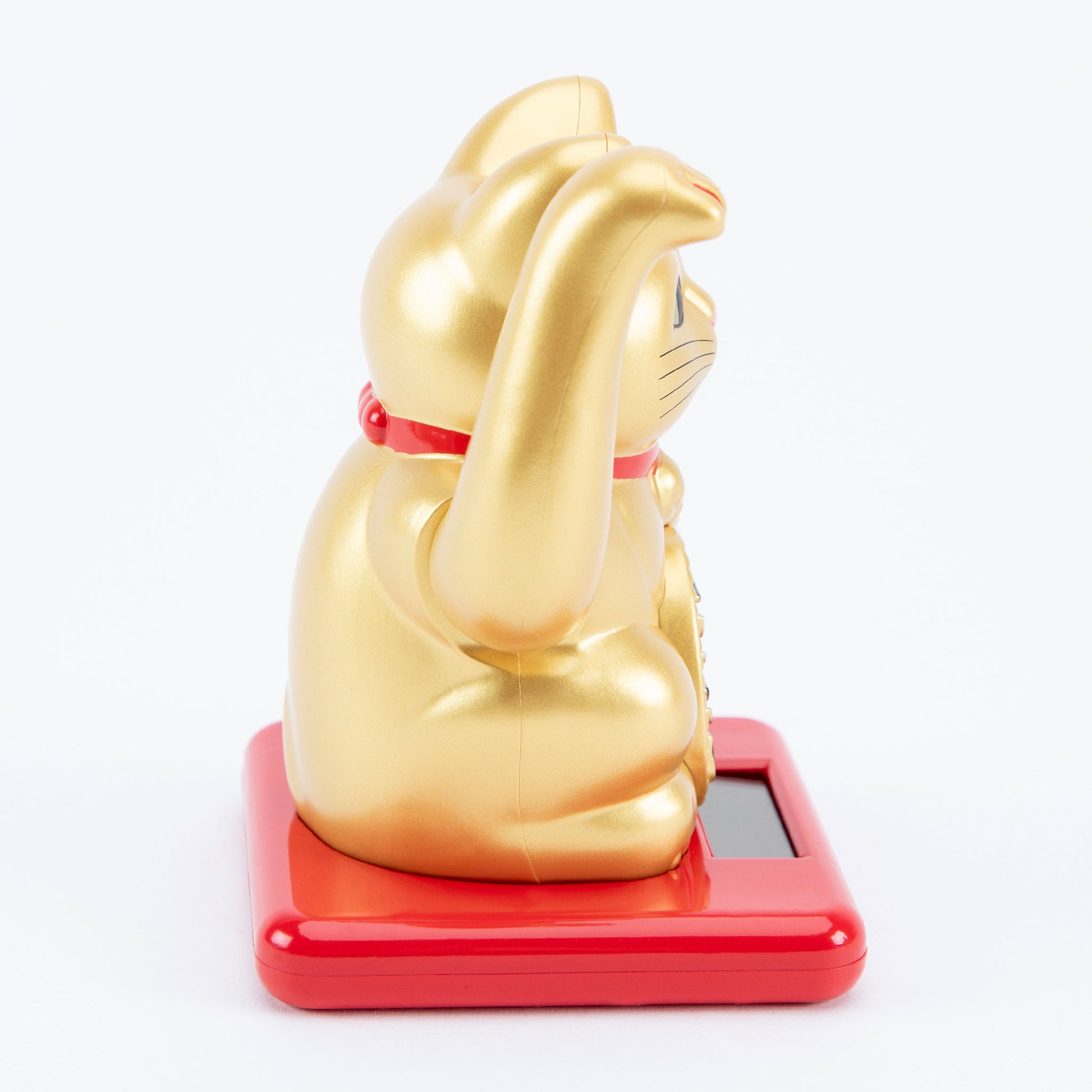 Gold maneki-neko cat on a red base with a white background