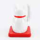White maneki-neko cat on a red base with a white background