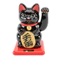 Black cat figurine with red base on white background