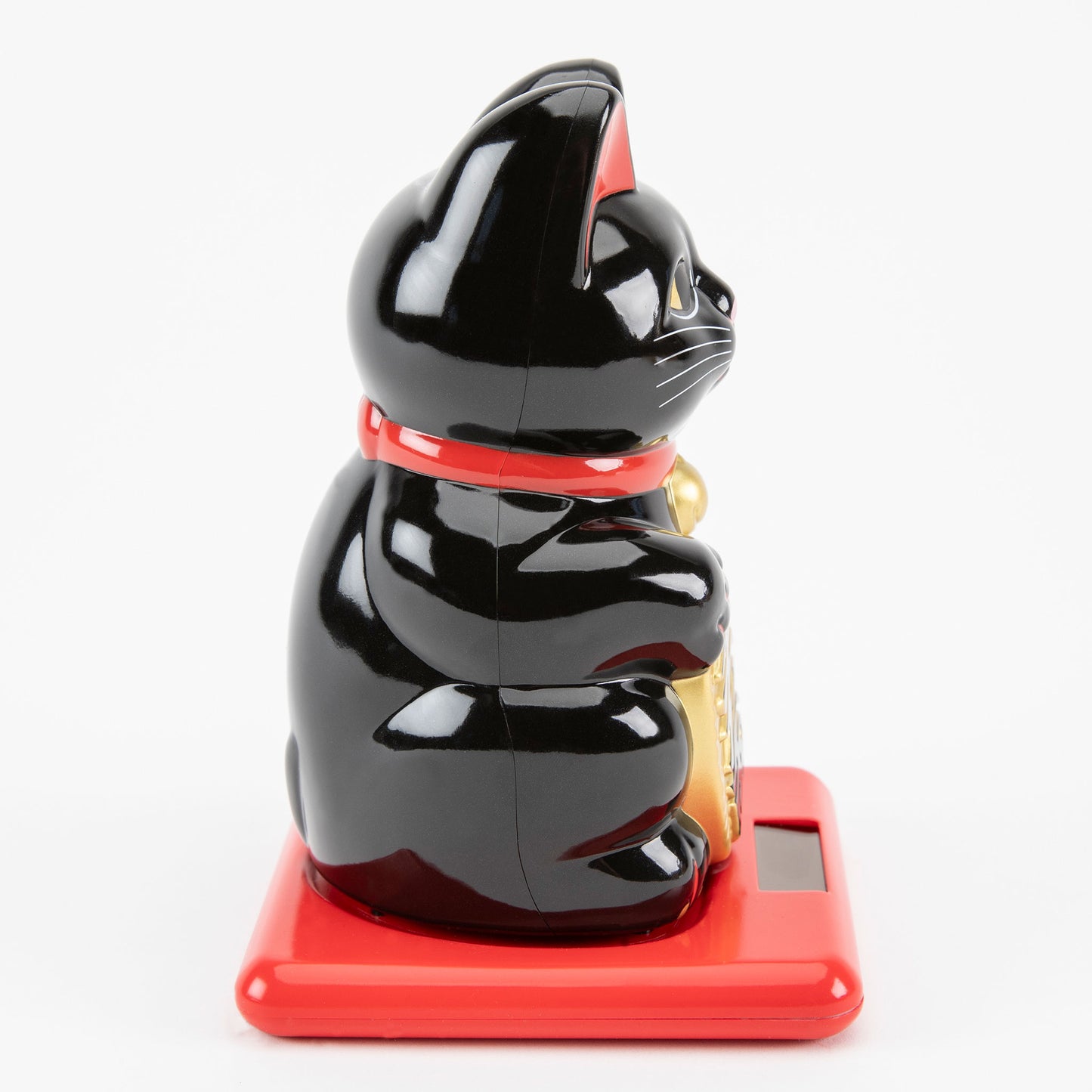 Black maneki-neko cat on a red base with a white background