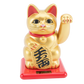 Gold cat figurine with red base on white background