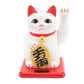 White cat figurine with red accents and gold pendant on a white background