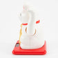 White maneki-neko cat on a red base with a white background