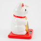 White maneki-neko cat on a red base with a white background