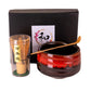 Tea set with red teapot, transparent cup, and wooden spoon on a white background