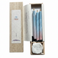 Three blue and pink candles in a wood box on a white background.