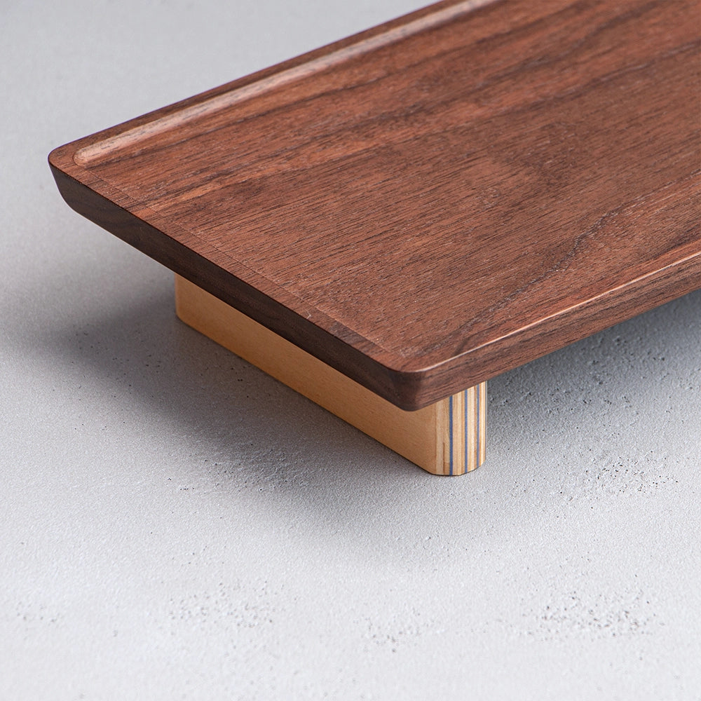 Wooden cutting board with a wooden handle on a light gray surface