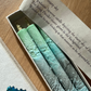 Three gradient candles in a box with a label on a wooden surface