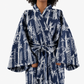 A person wearing a navy blue kimono-style robe with a white tropical and geometric bamboo print, shown against a plain light gray background.