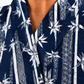 Close-up of a navy blue kimono-style top with a white bamboo and floral pattern, worn by a model.