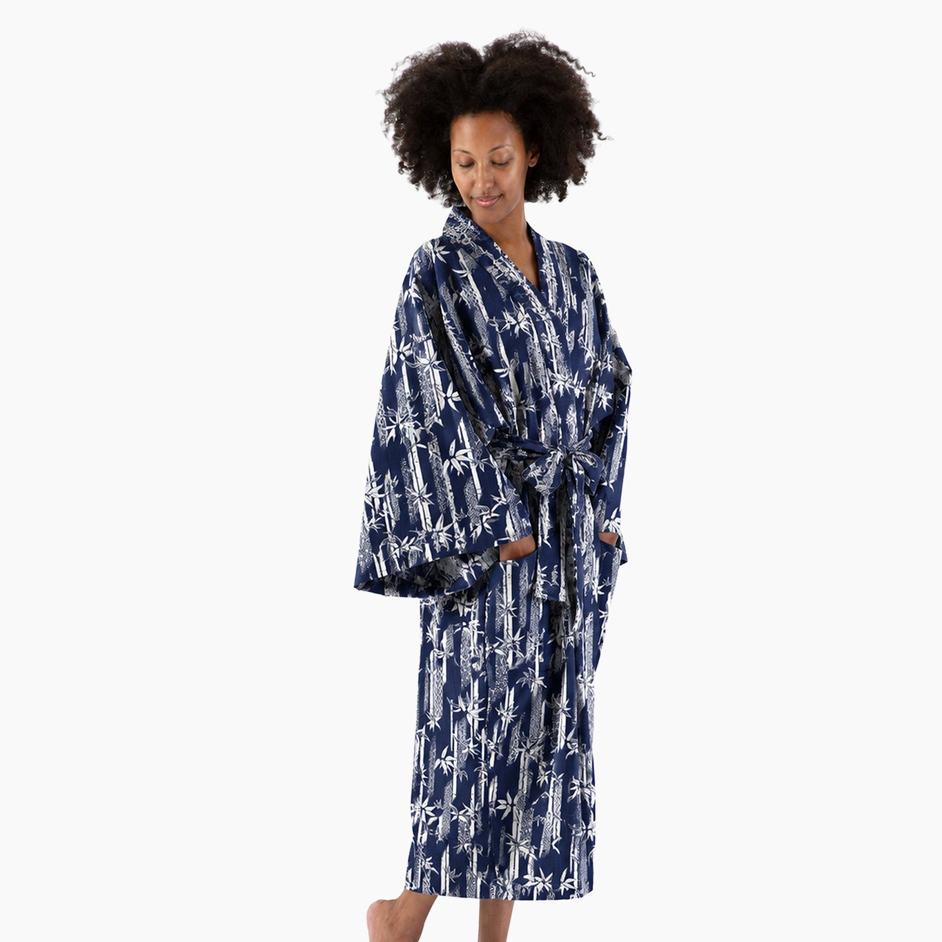 A woman modeling a long-sleeved navy blue robe with a white abstract pattern, standing against a plain white background.