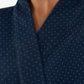 Close-up of a dark navy blue wrap-style garment with a small repeating white cross pattern, worn by a model.