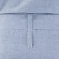 Close-up of a light blue garment with a belt and pocket detail.