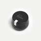 Black cosmetic jar with white label on a white background