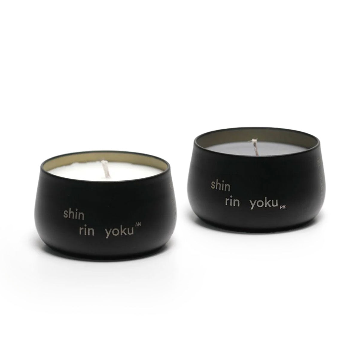 Two black candles with 'shin rin yoku' branding on a white background