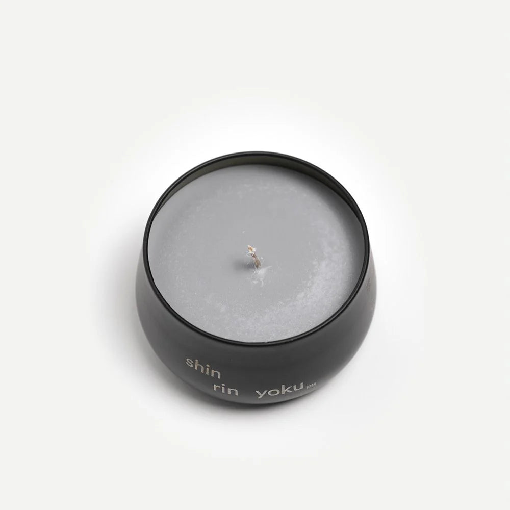 Candle in a black container with 'shin rin yoku' branding on a white background